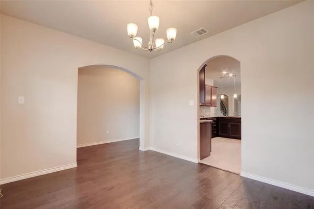 a view of a kitchen with wooden floor and a chandelier