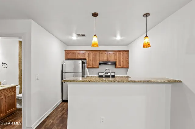 a bathroom with a granite countertop sink and a window