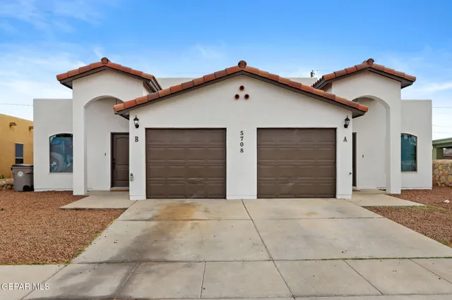 a view of house with a yard and garage
