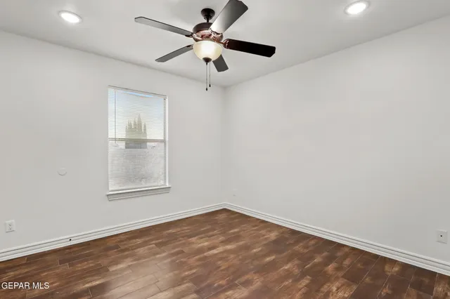 an empty room with a window and a ceiling fan