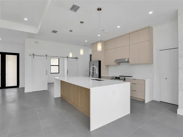 a kitchen with stainless steel appliances kitchen island granite countertop a stove and a sink