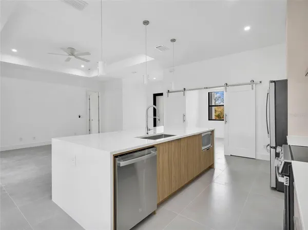 a large kitchen with stainless steel appliances a sink and refrigerator