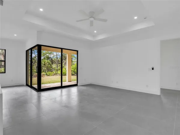 a view of a big room with windows and chandelier fan