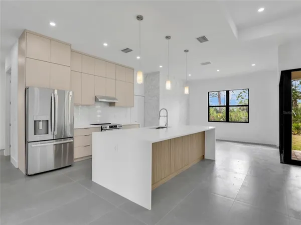 a large kitchen with stainless steel appliances kitchen island a large counter top and a stove