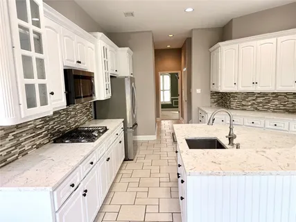 a bathroom with a granite countertop sink a large mirror and a shower