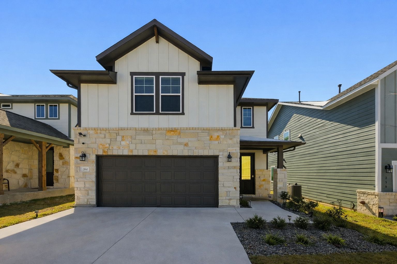 264 Denali Way Dripping Springs, TX 78620 - Photo 1 of 1 View of front of property with stone siding, a garage, board and batten siding, driveway, and covered porch