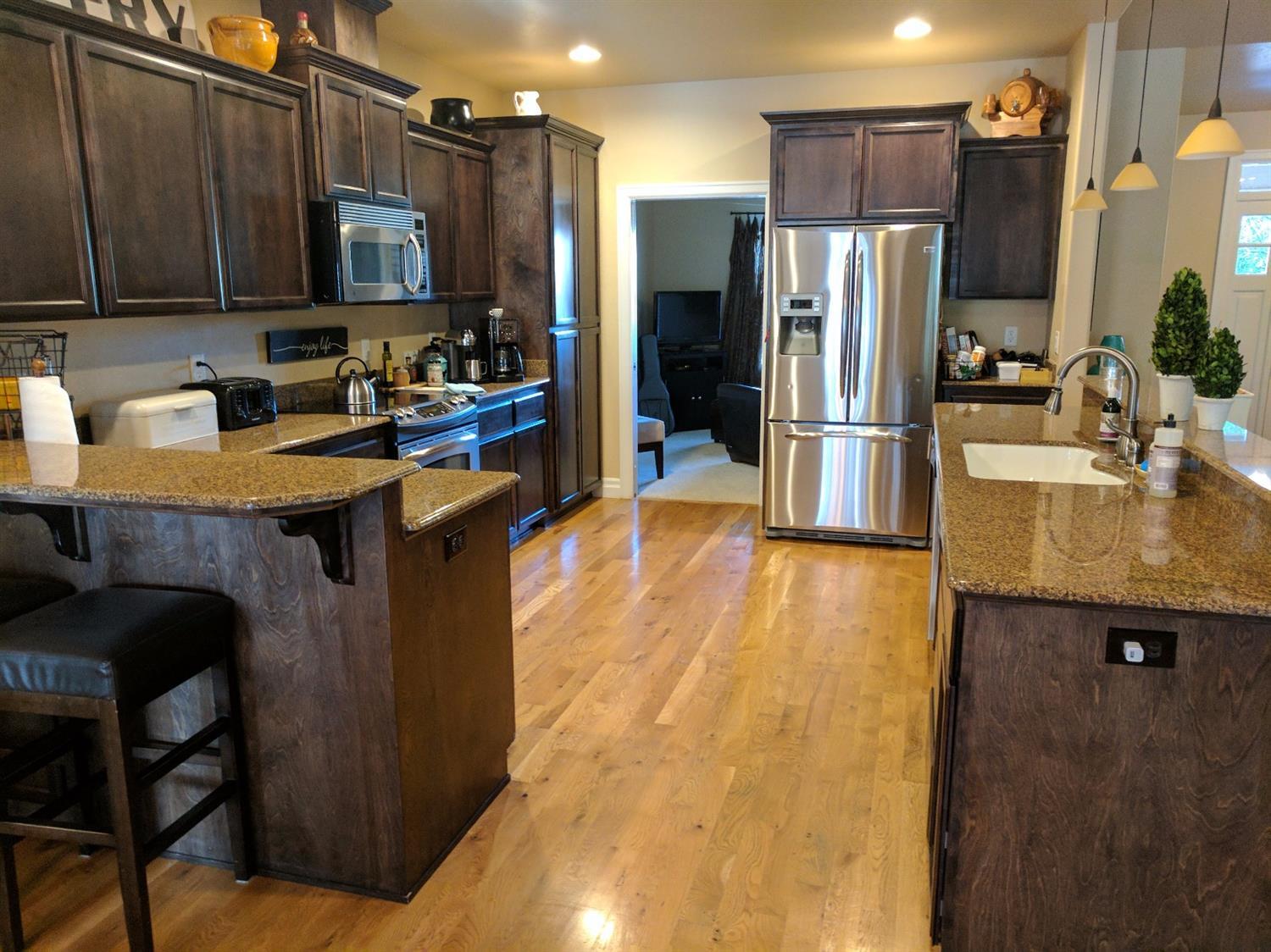 815 Buck Point Street Central Point, OR 97502 - Photo 5 of 15 a kitchen with stainless steel appliances granite countertop a refrigerator a stove and a sink
