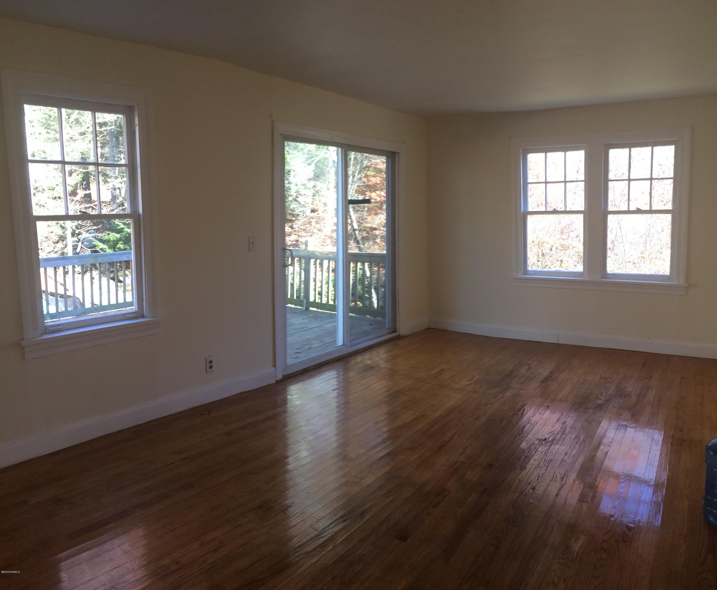 124 Sandisfield Road Sandisfield, MA 01255 - Photo 2 of 15 a view of an empty room with wooden floor and a window
