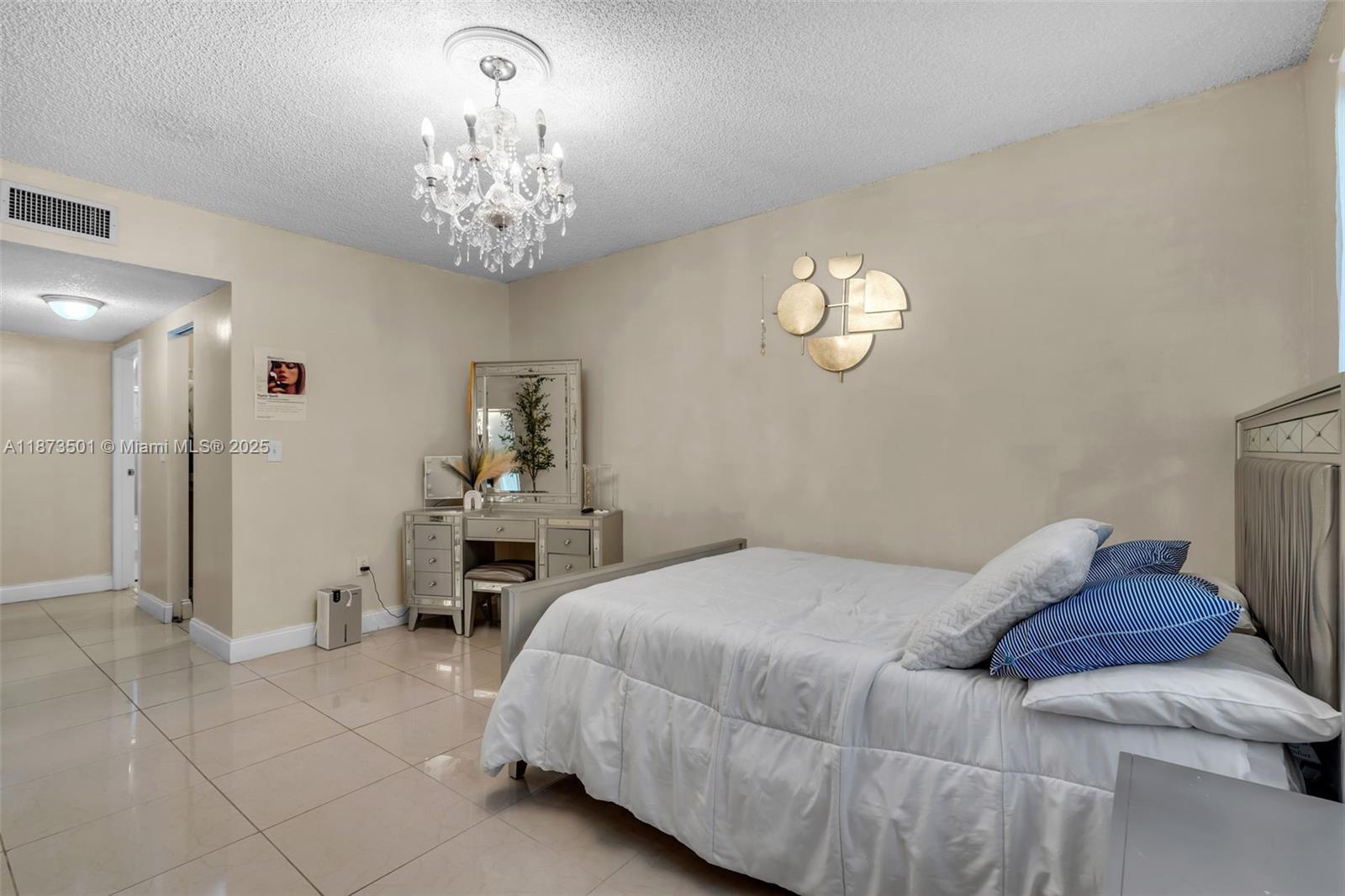 451 Ives Dairy Road, Unit 1031 Miami, FL 33179 - Photo 13 of 29 a bedroom with a bed and a chandelier