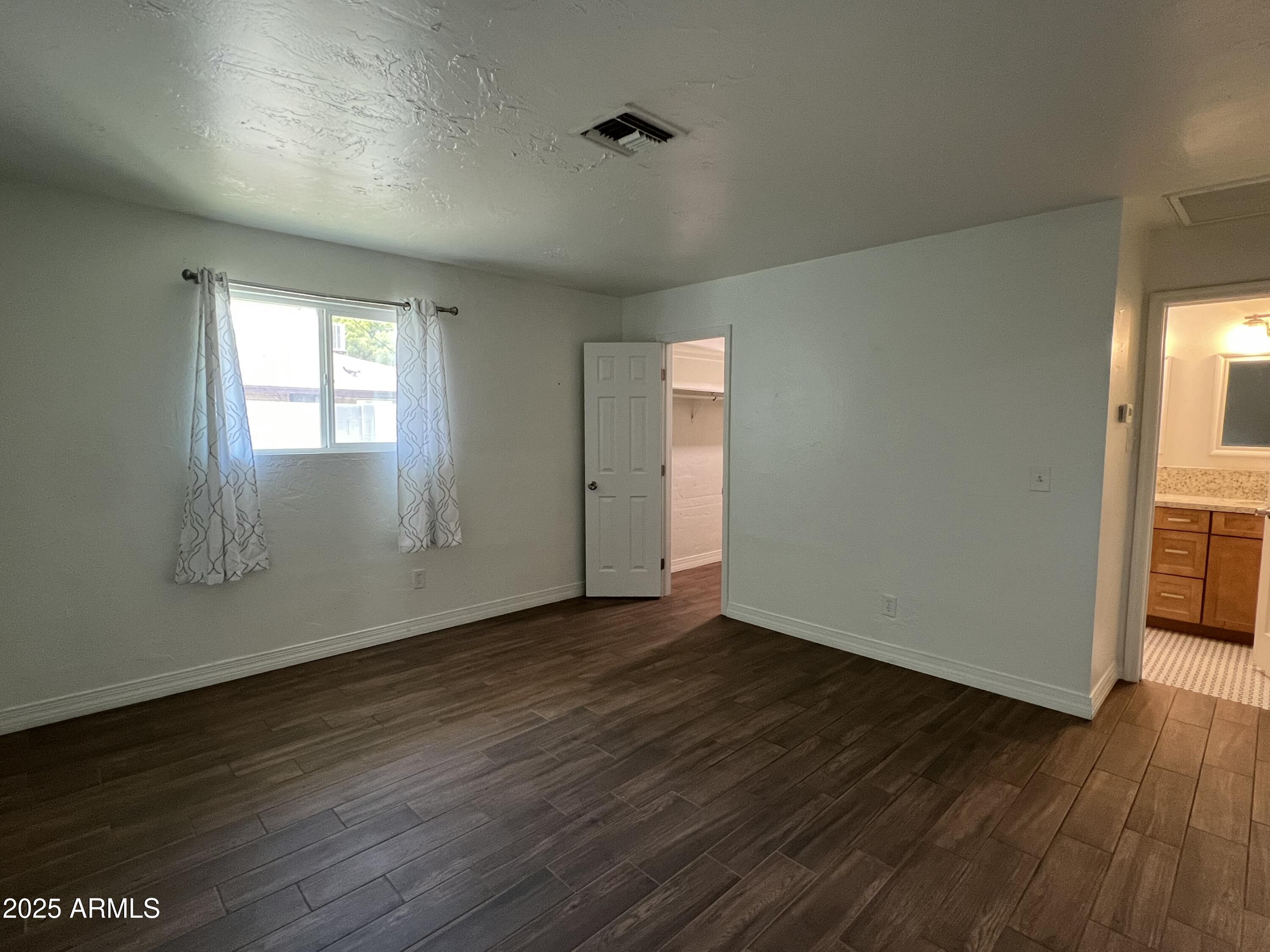 6202 North 14th Street, Unit 3/4 Phoenix, AZ 85014 - Photo 16 of 35 an empty room with wooden floor and windows