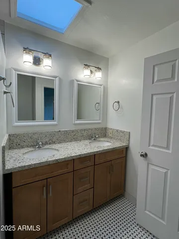 a bathroom with a granite countertop sink and a mirror