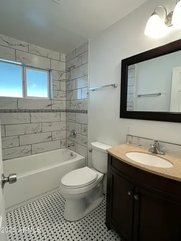 a bathroom with a toilet a sink a mirror and bathtub