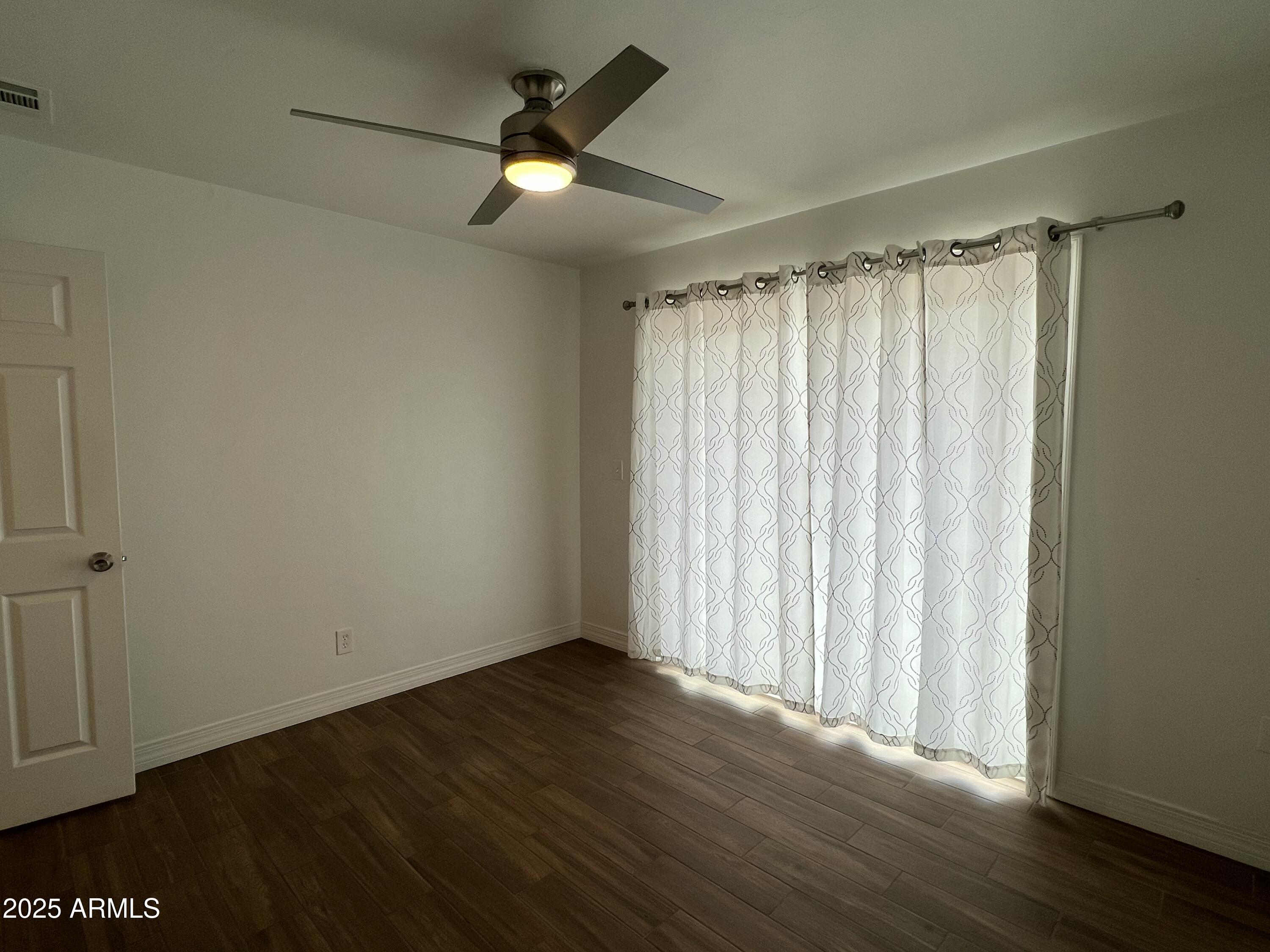 6202 North 14th Street, Unit 3/4 Phoenix, AZ 85014 - Photo 31 of 35 an empty room with wooden floor fan and windows