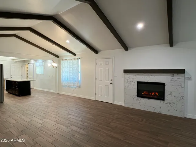 a view of a livingroom with a fireplace wooden floor and window