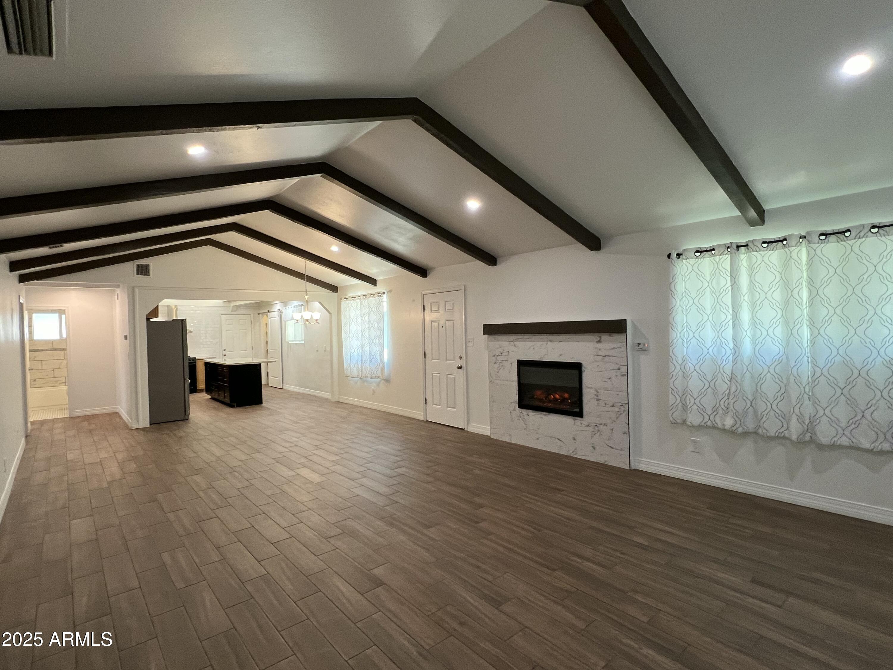 6202 North 14th Street, Unit 3/4 Phoenix, AZ 85014 - Photo 5 of 35 an empty room with wooden floor fireplace and windows