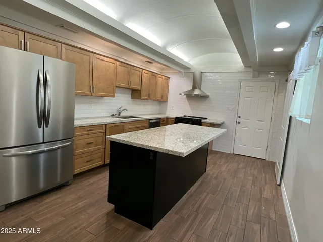 a kitchen with a sink refrigerator and cabinets