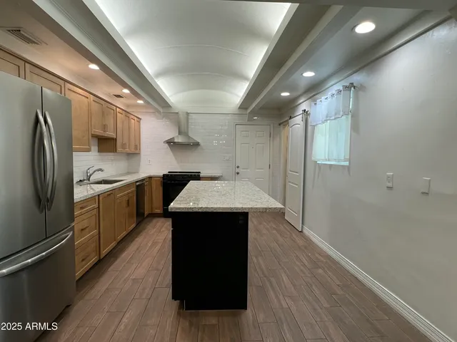 a kitchen with a sink a refrigerator and cabinets