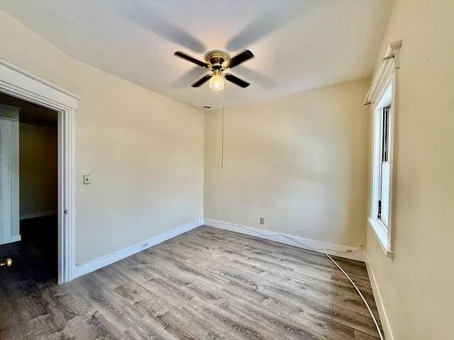 a view of a room with wooden floor and a ceiling fan