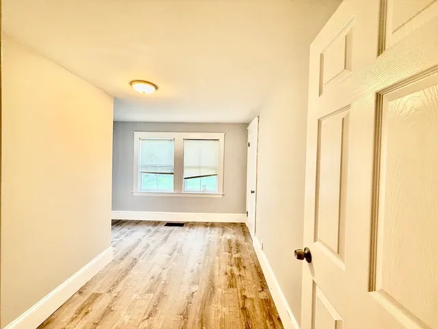 a view of a room with wooden floor and a window