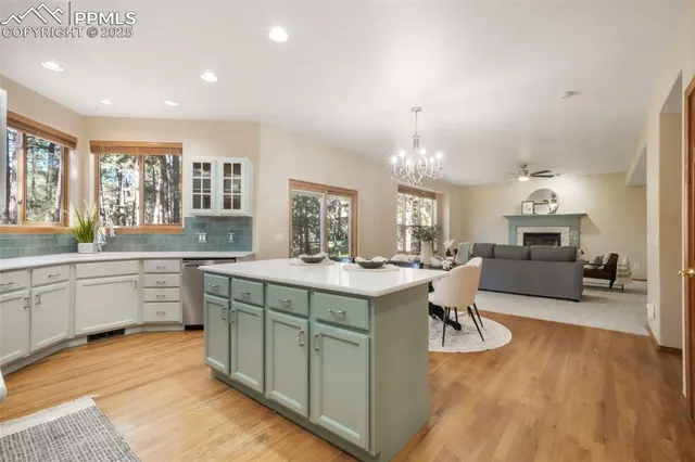 a large white kitchen with a sink and dishwasher a oven with wooden floor