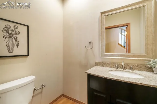a bathroom with a granite countertop sink mirror and toilet