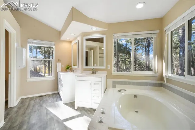 a bathroom with a bathtub sink and large window