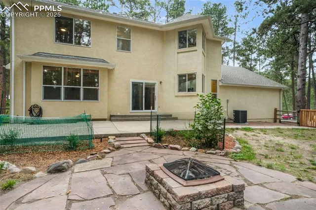 a view of a house with backyard and trees