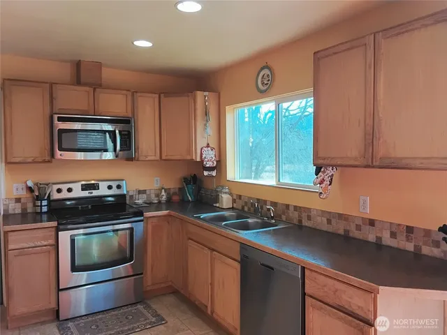a kitchen with a stove a sink and a microwave