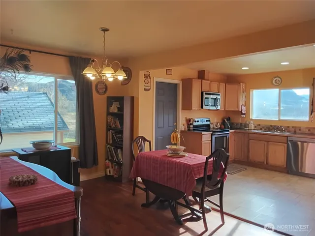 a kitchen with a dining table chairs and refrigerator