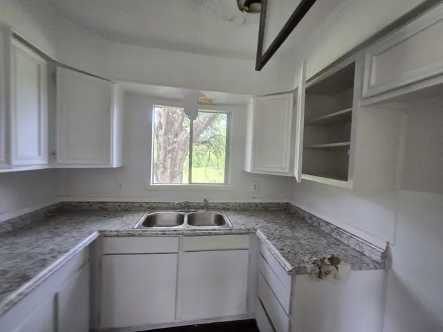 a room with a sink cabinets and window