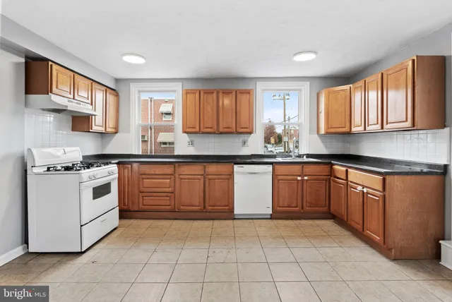 a kitchen with a stove sink and cabinets