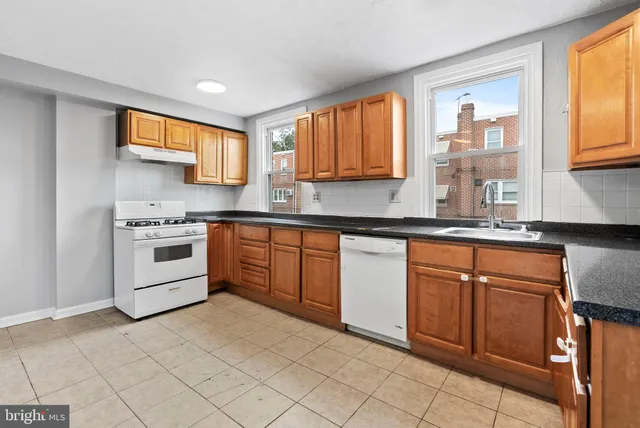 a kitchen with stainless steel appliances granite countertop a stove sink and cabinets
