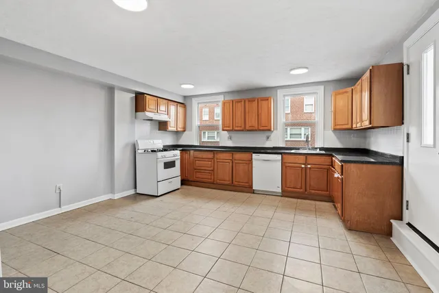 a kitchen with stainless steel appliances granite countertop a stove sink and cabinets