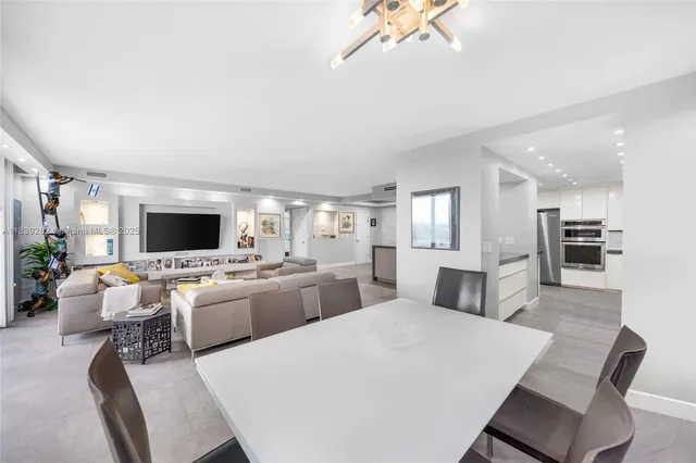 a large living room with stainless steel appliances kitchen island granite countertop furniture and a kitchen view