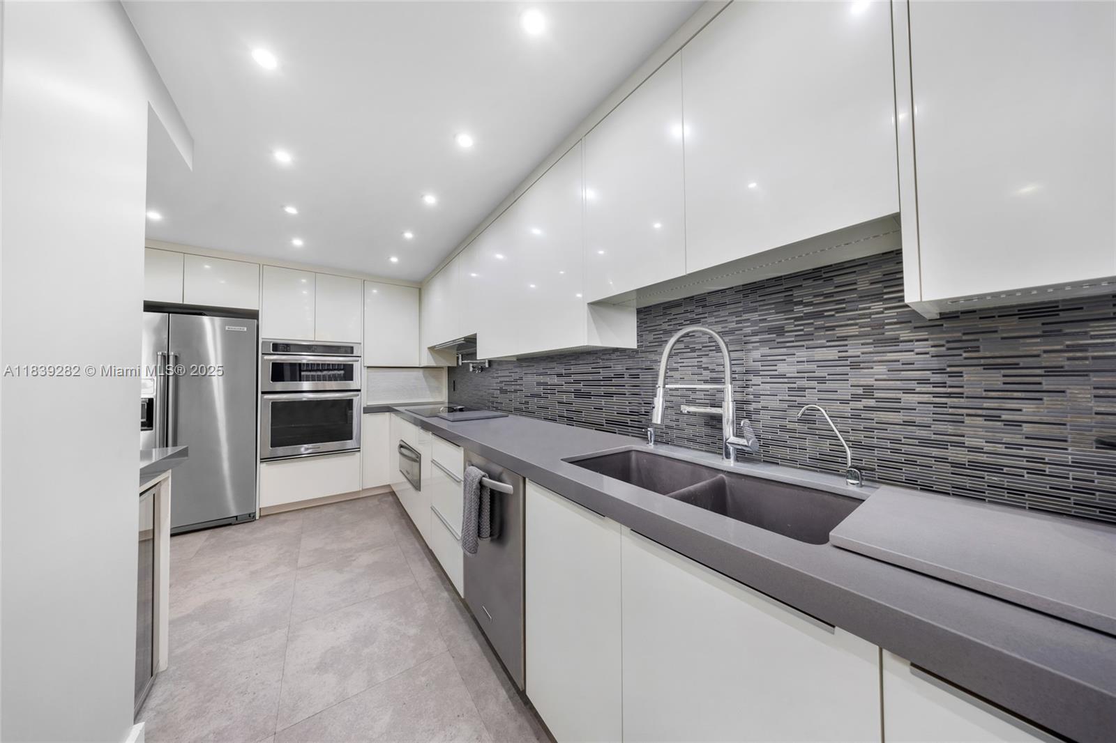 9801 Collins Avenue, Unit 16U Bal Harbour, FL 33154 - Photo 13 of 33 a kitchen with stainless steel appliances granite countertop a sink and refrigerator