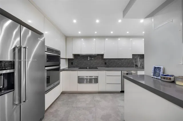 a kitchen with stainless steel appliances granite countertop a refrigerator and a stove top oven