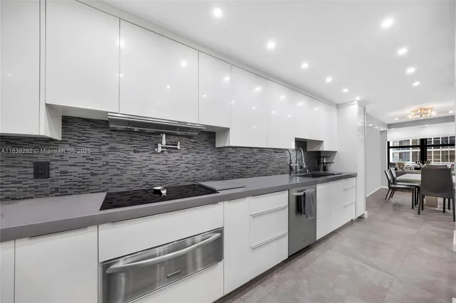 a kitchen with stainless steel appliances granite countertop a sink and white cabinets