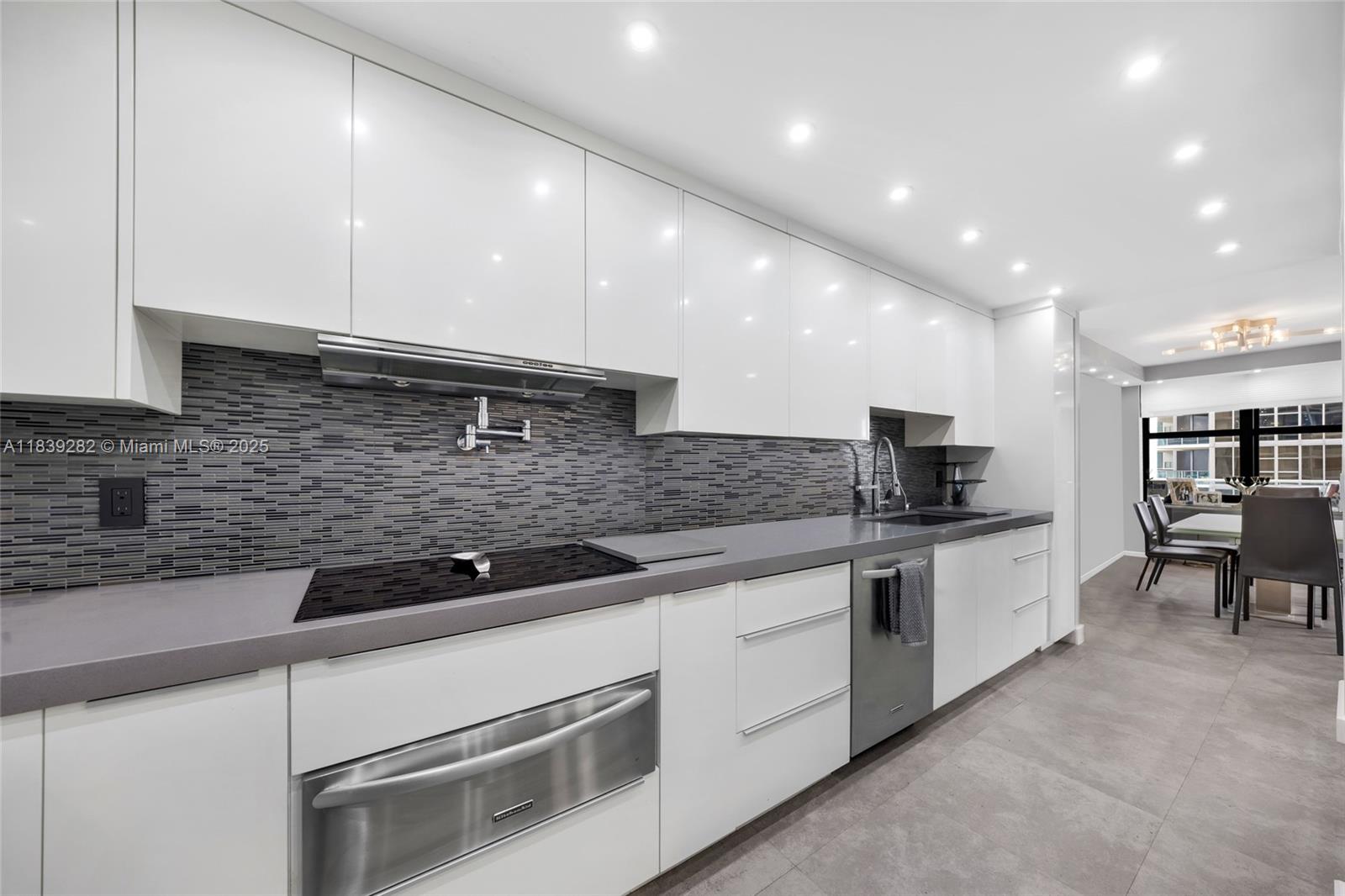 9801 Collins Avenue, Unit 16U Bal Harbour, FL 33154 - Photo 17 of 33 a kitchen with stainless steel appliances granite countertop a sink and white cabinets