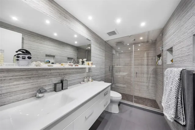 a bathroom with a double vanity sink toilet and shower