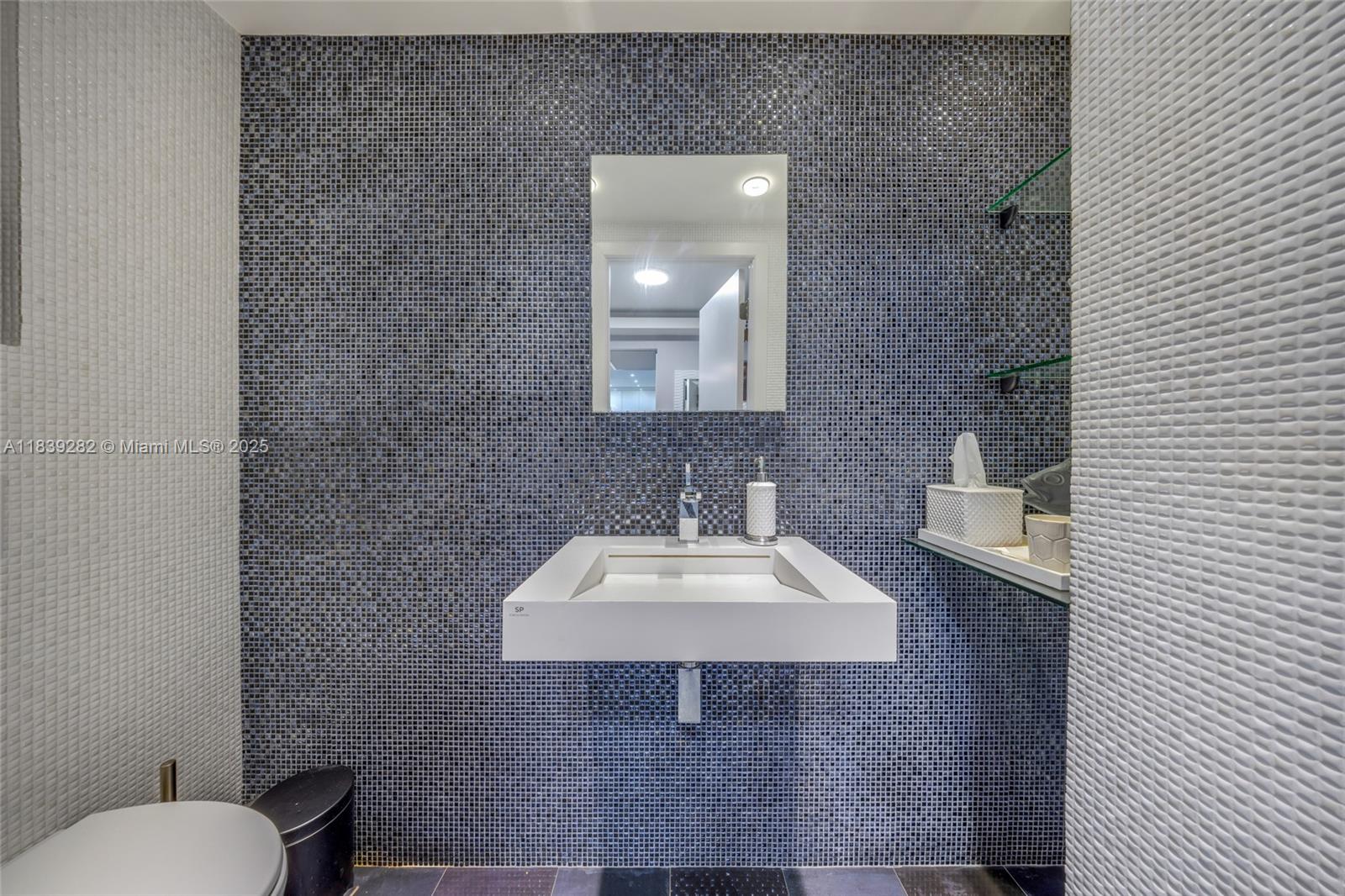 9801 Collins Avenue, Unit 16U Bal Harbour, FL 33154 - Photo 33 of 33 a bathroom with a sink a toilet and mirror