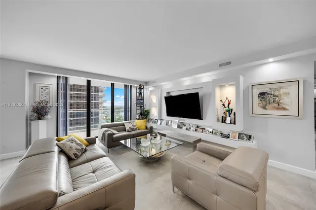 a living room with furniture flat screen tv and a large window