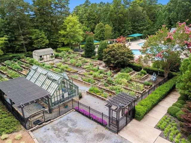 an aerial view of residential house with outdoor space and trees all around