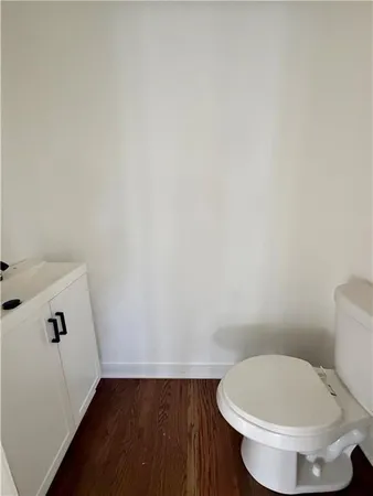 a white toilet sitting next to a white sink and vanity