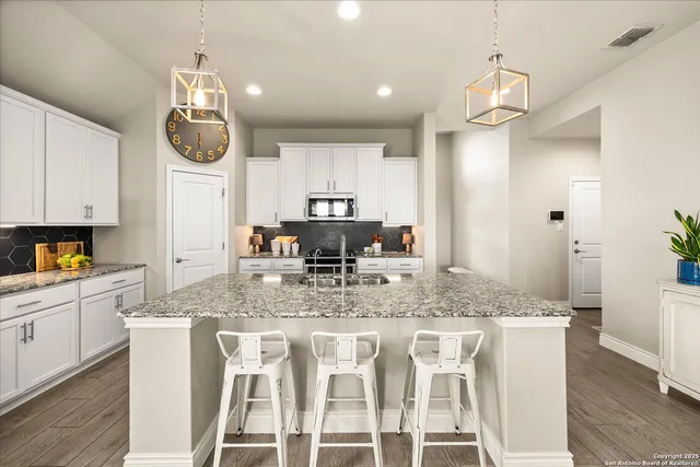a kitchen with stainless steel appliances granite countertop a sink and cabinets