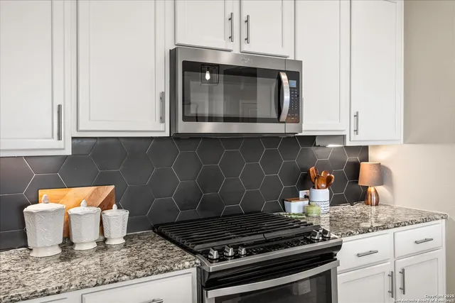 a kitchen with granite countertop a stove and a sink