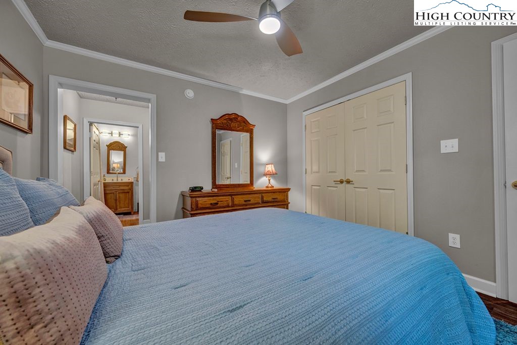 607 Charter Hills Road Beech Mountain, NC 28604 - Photo 8 of 31 a bedroom with a bed and a large mirror on the dresser