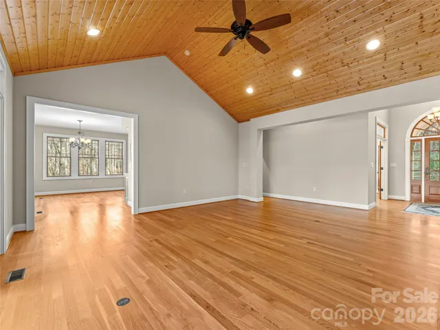 a view of empty room with wooden floor and fireplace
