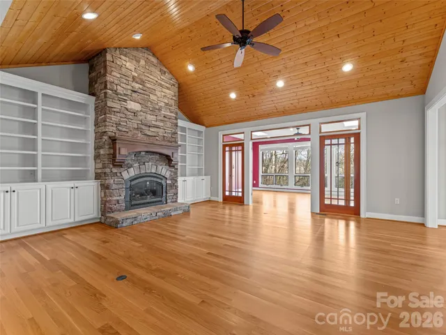 a view of empty room with wooden floor and fireplace