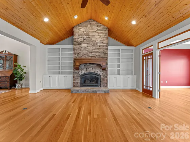 a large kitchen with stainless steel appliances a large counter top a stove and a chandelier