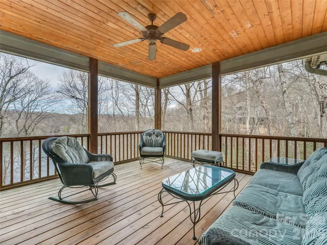 an empty room with wooden floor ceiling fan and windows